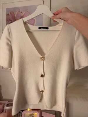 Topp med guldknappar - Fin topp med guldknappar, inte i dåligt skick men på bild två så hänger sista knappen ner som jag inte kunnat påverka (tyckte den redan var lite så när jag köpte den) plus en liten slitning på baksidan (sid 4) annars är det inga konstigheter 🫶🏼