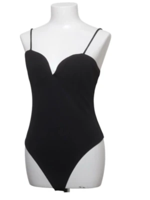 Svart body med tunna axelband - Stilren svart body med tunna axelband och djup urringning. Modellen har en figurnära passform och klassisk trosa nedtill. Perfekt att styla under skjortor eller tröjor. Bodyn är väldigt populär och slutsåld och den är ifrån ginatriclot i st L men skulle säga att den passar M ockås. De finns även kvar prislapp ifrån Sellpy 