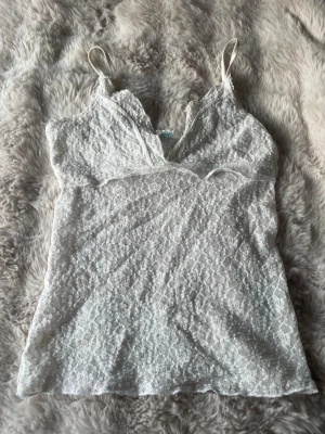 En vitt spetshund - En vit spelstopp perfekt till sommaren eller våren med en kofta över. Enkel och stretchigSäljer den eftersom att den är lite liten.