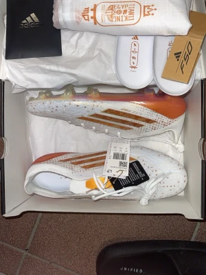 Adidas F50  - Säljer ett par Adidas F50 Salah i vitt med orange och guldiga detaljer. Stl 45. Aldrig använda!
