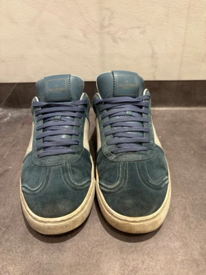 Valentino Flycrews - Snygga sneakers från Valentino i mocka. Skorna är lite smutsiga men går enkelt att rengöra, 7 nitar är borta och det är heeldrag (bild 5) där av det låga priset. Skorna är enkla och matcha med. Box, 2 dustbags, extra snöre och kort, allt OG medföljer!