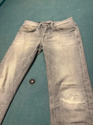 Dondup George - Säljer ett par ljusgråa dondup George i st 29. Endast använda vid fåtal tillfällen, därefter inga tecken på användning. Inköpta för ungefär 3600  på butiken W19 i Göteborg, kan gå ned i pris snabb affär. Kontakta vid frågor!    Tags finns säkert, behöver bara ta fram isf