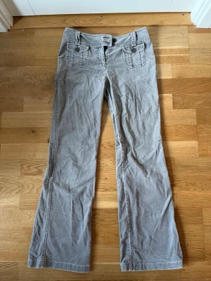 Manchester Byxor  - Ascoola ljusbruna byxor i Manchester tyg med jättenajs detaljer vid midjan! Skulle säga att de passar strl 34/36. Pris kan diskuteras 