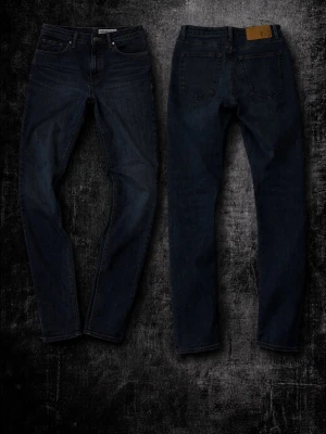 Mörkblå jeans från Tiger of Sweden - Snygga mörkblå jeans från Tiger of Sweden med klassisk femficksmodell och raka ben. Jeansen är tillverkade i slitstark denim och har diskreta sömmar samt en liten logotyp vid myntfickan. Perfekta för en stilren och modern look. Dessa är i ett super skick, och är som nya. Detta är ett måste i garderoben 