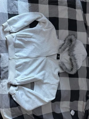 Päls Hoodie  - Vit hoodie med extremt skön päls runt kragen! Köpt för några månader sen men använt cirka 3 ggr, storlek M men kan även passa S