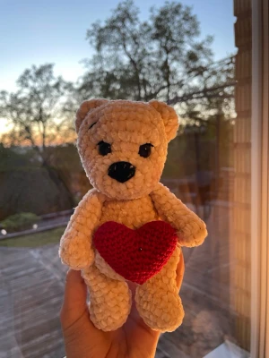 Mysig nalle med hjärta!♥️🧸 - Supergullig beige nallebjörn i mjuk plysch som håller ett virkat rött hjärta. Perfekt nu till mors dag eller att ge bort som present. En god liten vän som är unik virkad.