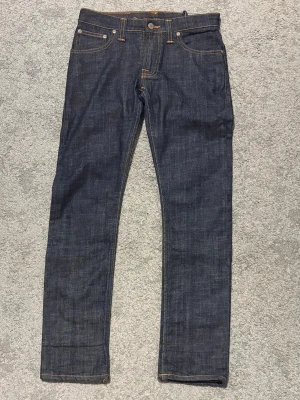 Nudie Jeans 28/30 - Säljer ett par mörkblåa jeans från Nudie Jeans med slim passform, modell Super Slim Kim. Sköna och stilrena jeans. Storlek W28 L30. Hör av dig vid frågor.