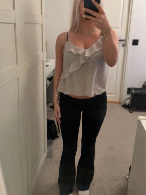 Beige topp med volang - Säljer beige topp med volangdetalj framtill från Gina Tricot i storlek 34. 