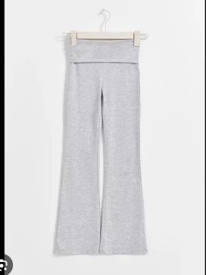 Yoga pants från Gina Young  - Snygga ljusgrå mjukisbyxor med bootcut-ben och bred linning. Tillverkade i mjukt och stretchigt material som ger en skön och avslappnad känsla. Perfekta för chill dagar eller när du vill ha en casual look.