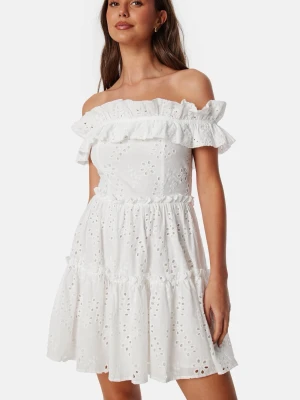 Vit off shoulder klänning - Superfin vit klänning med off shoulder-modell och volangdetaljer. Klänningen har broderade blommor och är gjord i ett lätt bomullstyg. Perfekt för studenten. Den är oanvänd och har lappen på köper då jag köpte fel storlek. Slutsåld!!