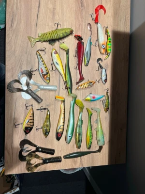 Stort set gäddfiskedrag. Ett par st customfärger - Säljer ett stort paket med fiskedrag och mjuka jiggar i olika färger och former. Innehåller både hårda wobblers och mjuka gummibeten, flera med realistiska fiskmönster i grönt, gult, svart, rött och silver. Perfekt för dig som gillar att fiska gädda, abborre eller gös.