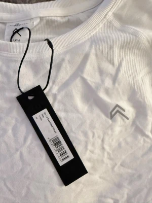 ONER ACTIVE TSHIRT - Säljer en vit T-shirt från Oner Active i modellen ”To go seamless fitted top” i ett väldigt tunt och gymvänligt material, rätt så ”compressive” ALDRIG ANVÄND