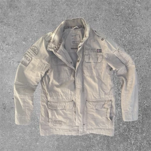Fieldjacka beige  - Riktigt snygg fieldjacket med detaljer. Har en lite fläck på bakre axel (se bild) men är i väldigt bra skick. Står storlek S men sitter som M. Skriv för mått eller annat!