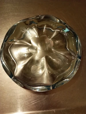 Orrefors Stella Polaris glasskål - Säljer en transparent Orrefors Stella Polaris glasskål med rund form och vågig kant. Skålen är tillverkad i tjockt glas och har en unik, organisk design som gör den till ett snyggt inslag i hemmet. Perfekt som dekoration eller för att förvara småsaker.