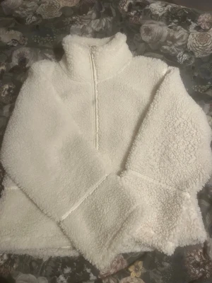 Vit Teddy jacka Gina tricot  - Säljer en vit Teddy jacka från gina tricot. Den är i fint skick men har en liten fläck vid dragkedjan ( bild 3 ). Den är i storlek 170