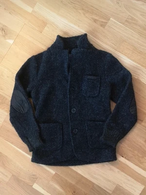 Mörkgrå/mörkblå kofta - Mysig mörkgrå/blå kofta från Zara Knitwear med knappar framtill, tre fickor och förstärkta armbågar i tyg.