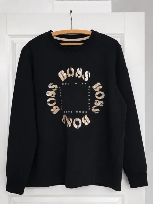 Svart Hugo boss sweatshirt  - Säljer en stilren svart crewneck från Hugo Boss i mycket fint skick. Tröjan har en clean och modern design med diskret men snygg BOSS-logga framtill i cirkulärt motiv som ger ett exklusivt uttryck utan att bli för mycket. Väldigt lite använd, säljer pågrund av att den inte används