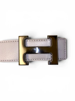 Vitt skärp med silverspänne H - Säljer denna stilrena vitt skärp med ett ikoniskt H-format silverspänne. Skärpet är gjort i skinn och har en klassisk, elegant design som lyfter vilken outfit som helst.