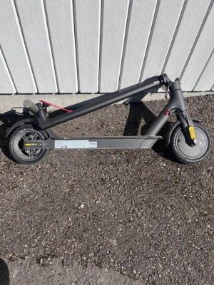 Svart elscooter.  kan byta mot nåt - Säljer en svart elscooter med hopfällbar design. Scootern har gråa handtag, svarta hjul och detaljer i rött och gult. Perfekt för att ta sig fram snabbt i stan. Laddas enkelt och har en robust ram i metall. punka i bakdäcket. Syret behöver fixas lite för det gör att vika på de. Det står inte hur mycket den går 