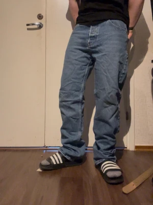 Relaxed blå jeans med rak passform - Baggy jeans i ljusblå denim med rak passform och klassiska fem fickor. Jeansen har en avslappnad look med breda ben och normal midja. Perfekta för en streetwear-stil och passar till sneakers eller slides.