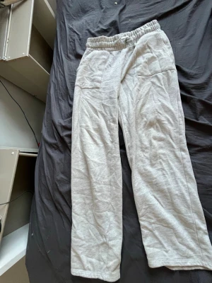 Grå mjukisbyxor från 157 - Snygga och bekväma grå mjukisbyxor från 157 med resår i midjan och raka ben. Perfekta för chill dagar hemma eller när du vill ha en avslappnad stil. Tillverkade i mjukt material som känns skönt mot huden.