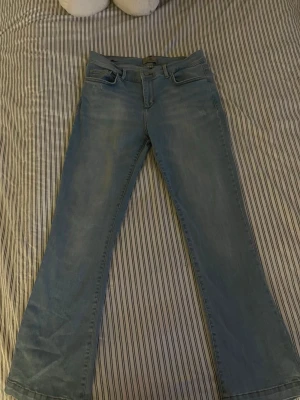 Ljusblå bootcut jeans från LTB - Säljer ett par ljusblå bootcut jeans från LTB med klassisk femficksdesign och snygga detaljer på bakfickorna. Jeansen är mid-waist. Stretchiga och väldigt bekväma. Säljer dem för att de inte riktigt passar mig i längden (är 158).