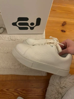 Vita sneakers från Eytys - Stilrena vita sneakers från Eytys med lågt skaft och chunky sula. Skorna är gjorda i ett texturerat lädermaterial och har vita skosnören. Perfekta för dig som gillar minimalistisk och clean stil. Nypris är 2200 och jag har enbart testat dem, men dem var för små och hann inte skicka tillbaka… ❤️