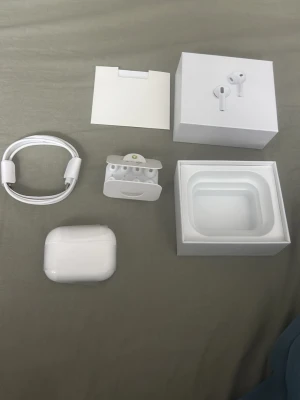 Apple AirPods Pro med laddningsetui - Apple AirPods Pro i vit färg med trådlöst laddningsetui, silikonproppar i olika storlekar och USB-C till Lightning-kabel. Snygg och stilren design i blank plast, perfekt för dig som vill ha grymt ljud och brusreducering.