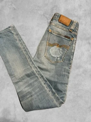 Ljusblåa jeans ifrån nudie jeans - Säljer nu ett par ljusblåa nudie jeans i storlek W26 L32!