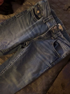 Blå bootcut jeans Gina Tricot 164 - Säljer ett par blå low waist bootcut jeans från Gina Tricot i storlek 164. 