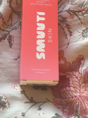 Smuuti Skin Wrapping Mask - En rosa ansiktsmask från Smuuti Skin med jordgubbsextrakt och vitamin C. Masken kommer i en tub och är perfekt för dig som vill boosta huden med fukt och lyster. Fräsch doft och smidig att applicera.