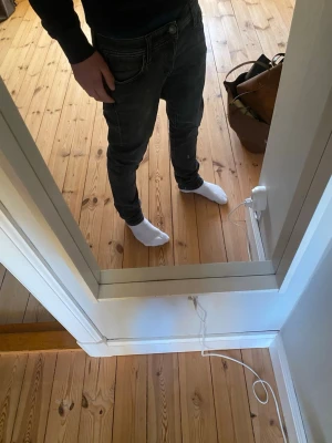 Svarta slim fit jeans - Säljer ett par svarta slim fit jeans med klassisk femficksdesign och normal midja. Jeansen har en lätt tvättad look och är perfekta för en modern stil. Perfekta för dig som gillar en stilren och enkel look.