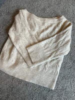Beige kabelstickad tröja Gina Tricot - Mysig beige stickad of shoulder tröja, sticks lite men funkar bra med t.ex ett linne under. 