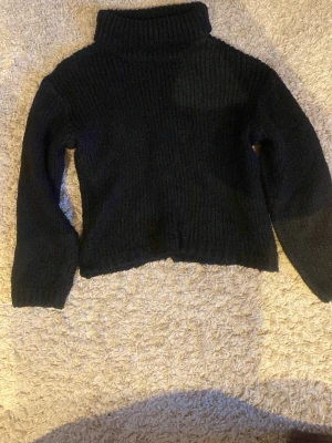 Stickad polo tröja med detaljer på armen och axlarna. - En stickad tröja med vikbar-polo. Fina detaljer på både axlar och armar.