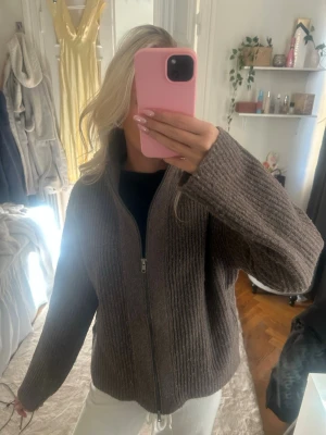 Brun ribbstickad ziptröja - Mysig brun ribbstickad tröja med dragkedja framtill och hög krage. Använd 1 gång 