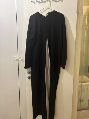 Svart abaya med puderrosa slits - Superfin och elegant abaya i färgen svart och puderrosa. Har inte sett liknande klänning nån annanstans och får allrid komplimanger när jag bär den!😍