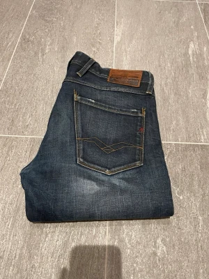 Replay jeans - Replay anbass i snygg tvätt och lite slitningar på rumpan. Fräscha jeans som passar till alla outfits! Storlek 32/32. Tveka inte på att höra av dig vid frågor!