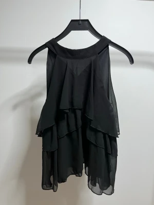 Svart volang topp från Shein - Säljer en svart ärmlös topp med flera lager volanger från shein, bara testad