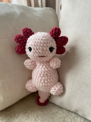 Virkad axolotl  - Supergullig, handvirkad axolotl av mjukt rosa chenillegarn. Mjukisdjuret har svarta säkerhetsögon i plast och rekommenderas därför inte för barn under 3 år. Mjukisdjuret är ca 23 cm högt 🧶