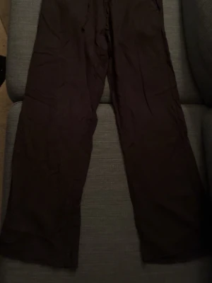 Svarta linnebyxor från 157 XS - Svarta linnebyxor från 157 i storlek XS. Byxorna har rak och avslappnad passform med resår i midjan. Tillverkade i ett lätt och luftigt linnematerial som ger en skön känsla. Perfekta för en chill och stilren look.