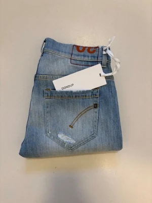 Nya DonDup George jeans - Ljusblåa DonDup George jeans med slitningar//  Helt nya med tagg 10/10 skick //  Nypris: 1795 DKK //  Storlek 30 //  Mått  Midja bredd 38cm  Längd 102cm  Skriv vid minsta fråga eller fundering🤝 
