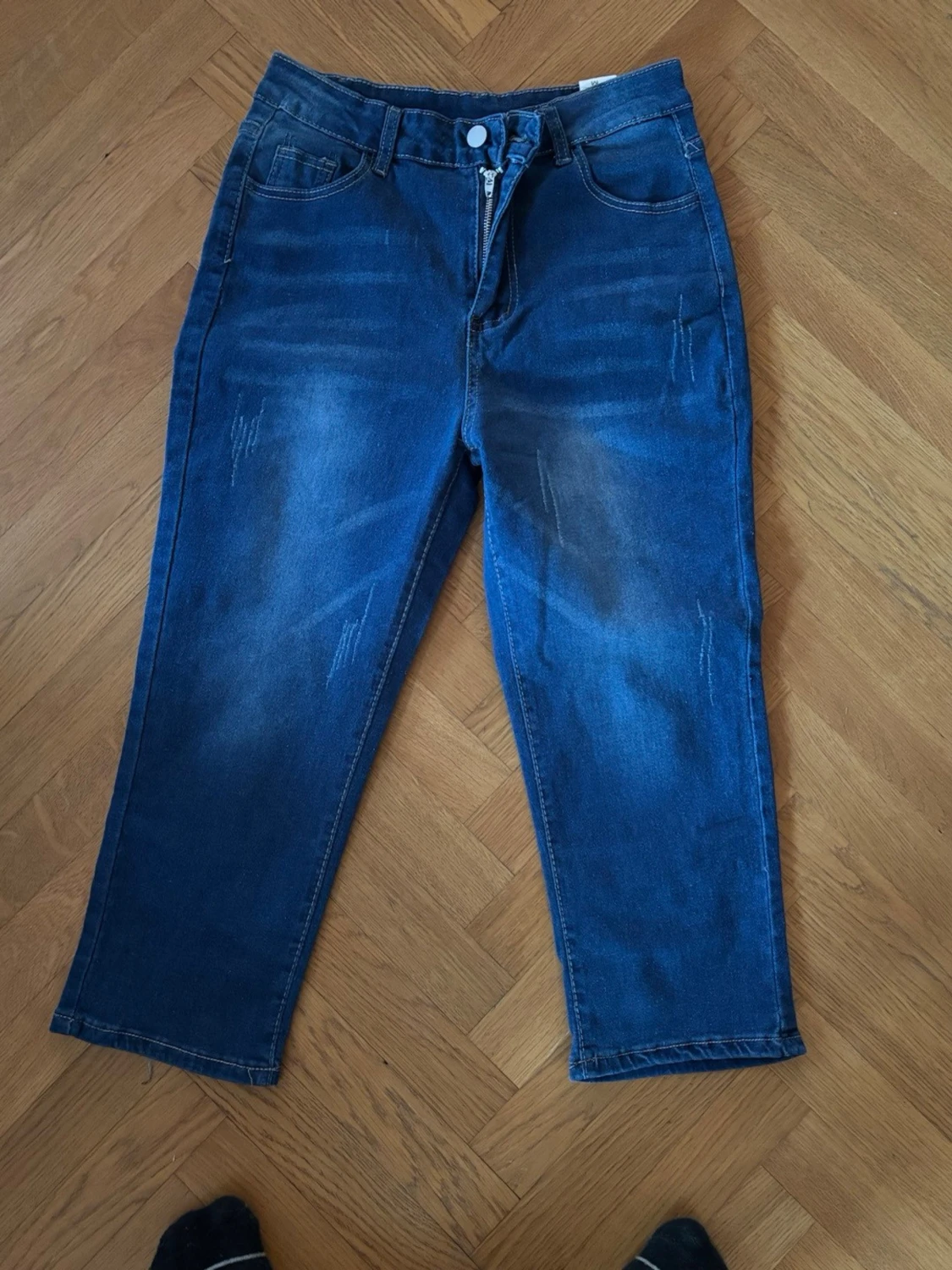 Blå raka jeans med slitningar
