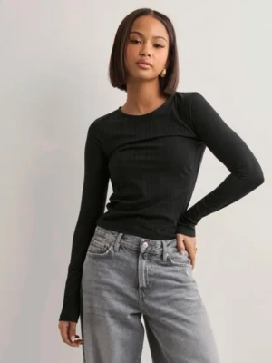 Svart ribbad långärmad topp med öppen rygg - Svart långärmad topp från Nelly med ribbad struktur och en stor öppen rygg som knyts med snören. 