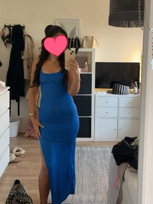 Lång blå klänning - Lång blå klänning med slits och öppen rygg med korsande band, storlek S