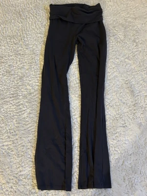 Mörkgråa yogapants  - Mörkgråa yogapants med utsvängda ben och låg midja. Köpt på Gina tricot i storlek xs. Är 163 cm