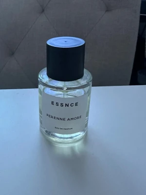 ESSNCE Perenne Amore Eau de Parfum - ESSNCE Perenne Amore Eau de Parfum i en stilren, rund glasflaska med svart lock. Syns på bilden hur mycket som är kvar☺️