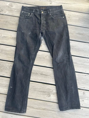 Nudie svarta selvage grim tim - Ett par super fetta svarta selvage jeans från Nudie i modellen Grim Tim i superbra skick. strl 32/32 men utgå från måtten Längd: 100 cm Midja tvärsöver: 41 cm  Benöppning: 19 cm