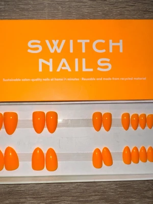 Switch Nails Disco Tangerine mandelform - Snygga press-on naglar från Switch Nails i modellen Disco Tangerine. Färgen är en intensiv orange och formen är kort mandel. Tillverkade av återvunnet material och kan återanvändas. Perfekt för dig som vill ha salongskänsla hemma på nolltid. Säljes utan tillbehör.