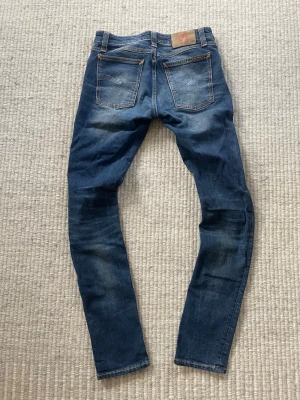 Blå slim fit jeans från Nudie Jeans - Säljer nu ett par feta nudie jeans! Modell skinny lin! Ny pris runt 2000kr! Hör av er vid minsta lilla fundering W28 L32! Midja= 37cm längd ca= 100cm! Först i kvarn!