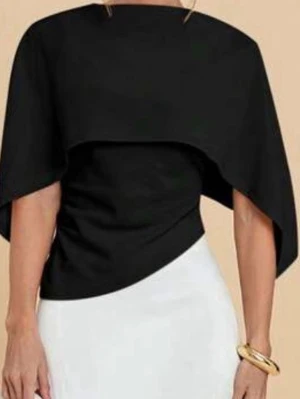 Cape top - Trendig svart topp med asymmetrisk design och vida, korta ärmar. Viral cape top. Toppen har en unik omlottliknande form, och indragen på sidorna så den formar kroppen
